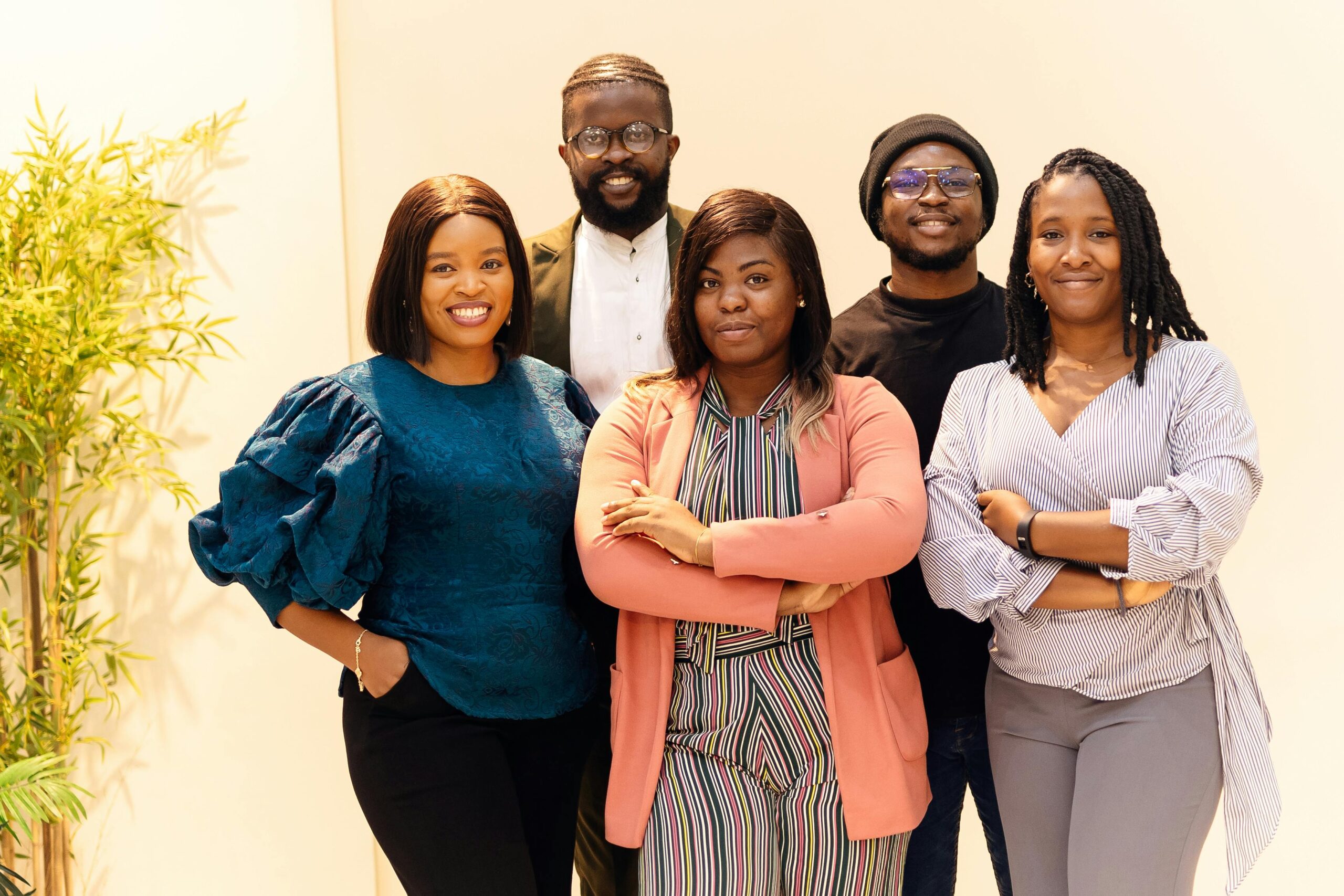 About Us A diverse group of business professionals smiling confidently indoors.